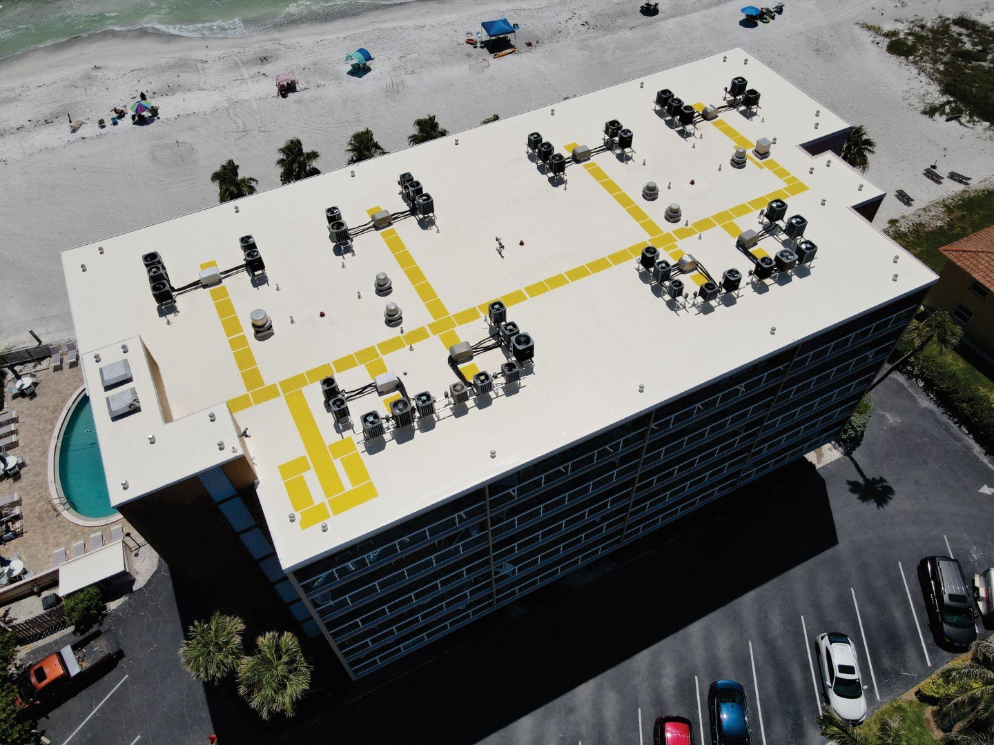 Single ply membrane roof with walkway pads routed around rooftop equipment